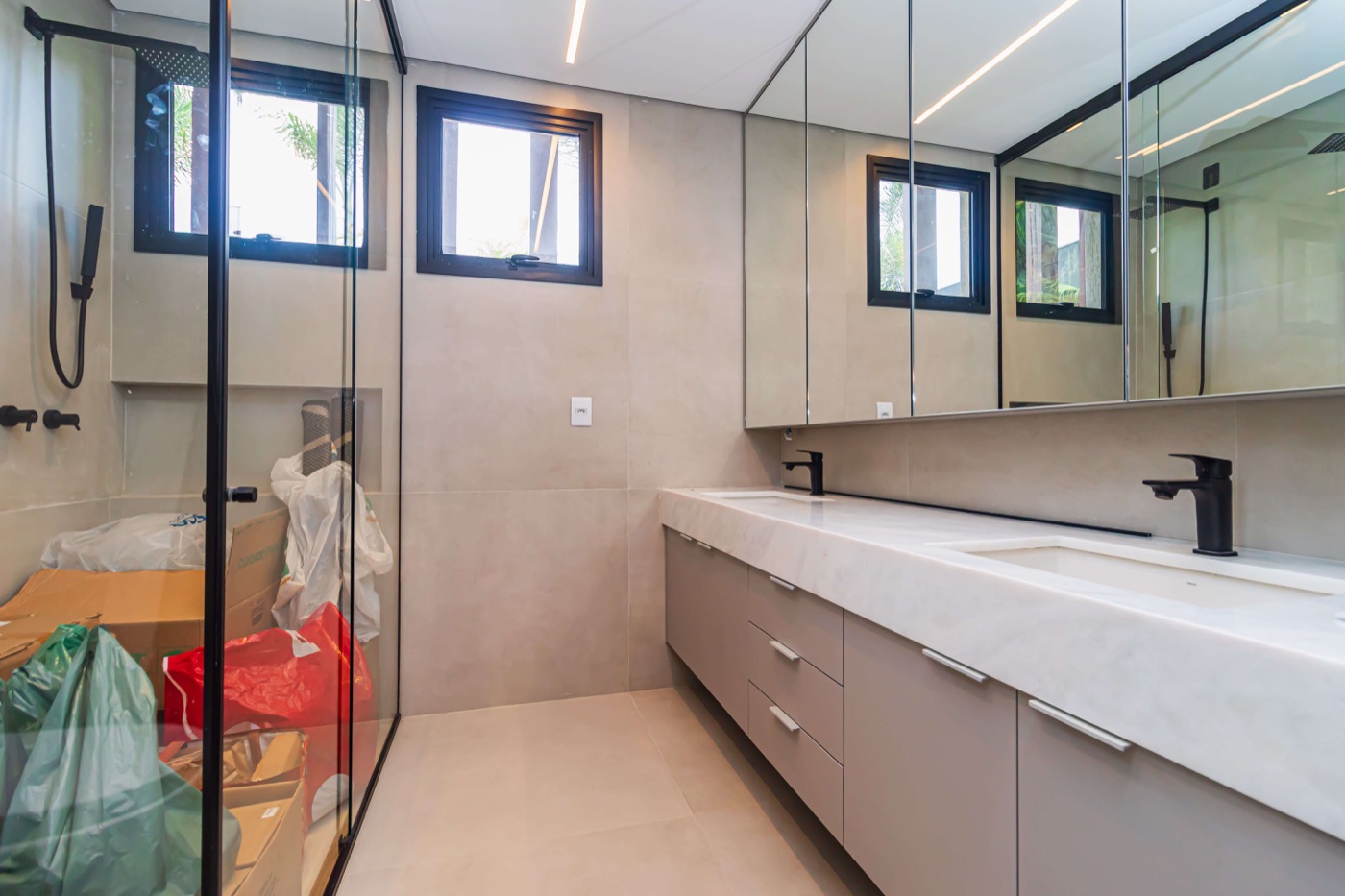 Banheiro com espelhos e box de vidro