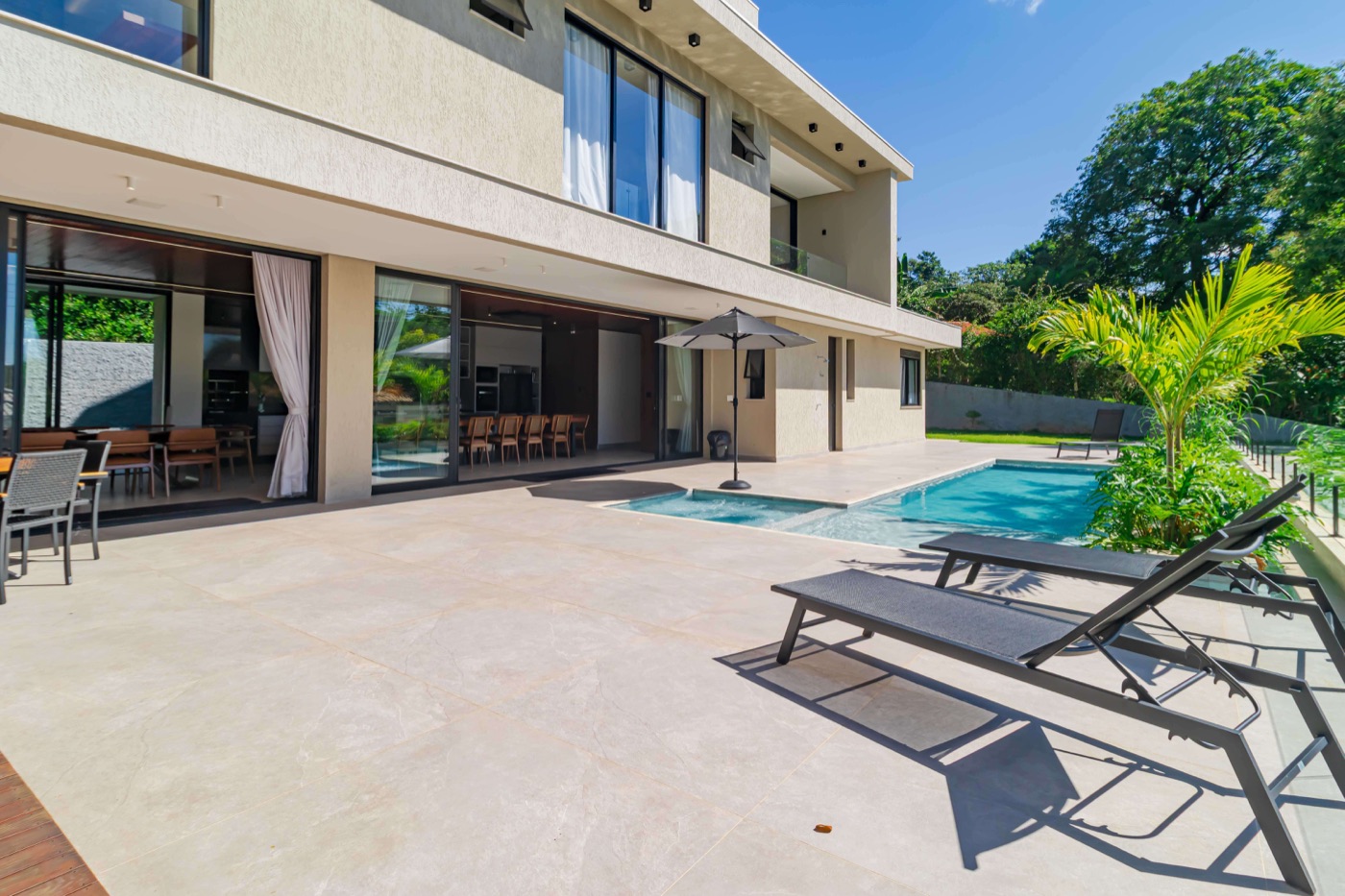 Vista da fachada posterior com piscina e espreguiçadeiras