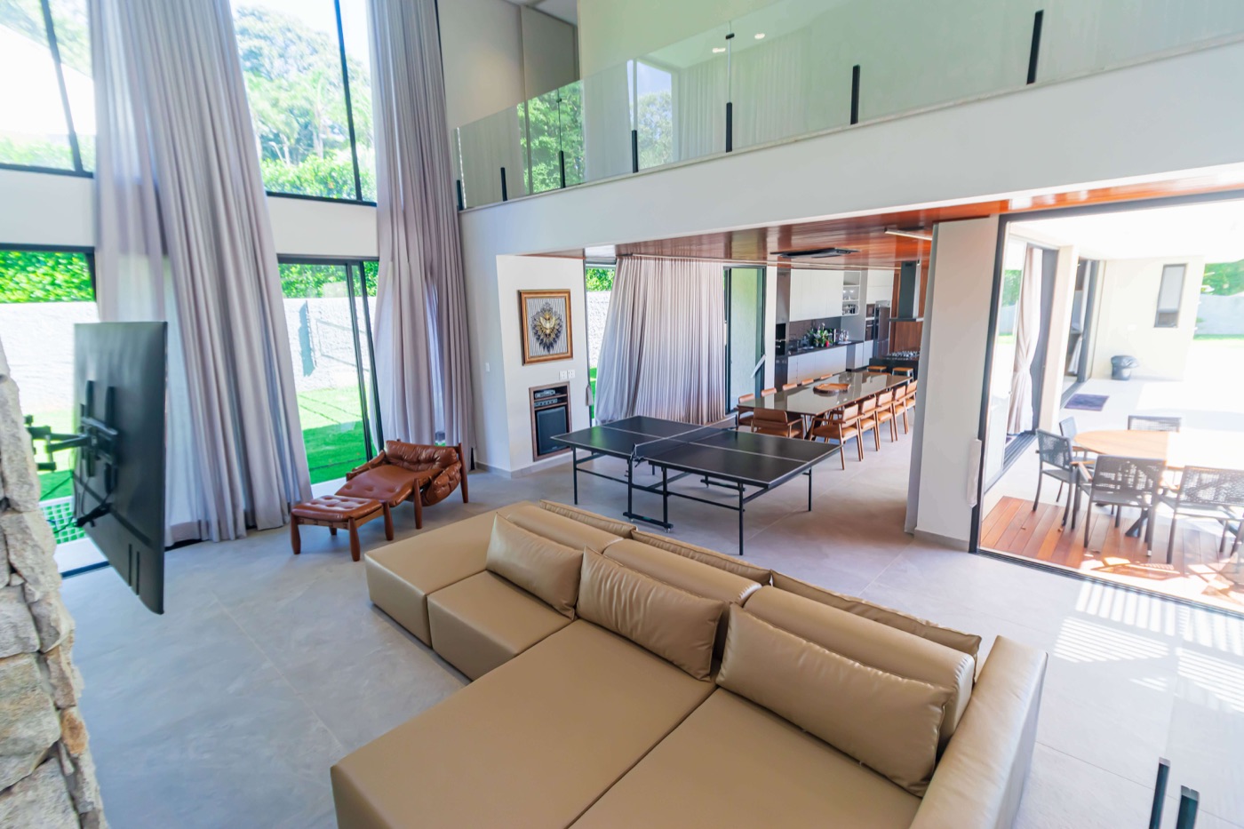 Sala de estar integrada ao jardim, com grandes portas de vidro